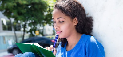 Learning latin female student with curly hair outdoor in the city